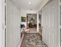 View of the foyer with an antique chair and decorative rug, with a glimpse into other rooms at 13424 Se 89Th Terrace Rd, Summerfield, FL 34491