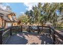 Wide wooden deck with railings offers scenic neighborhood views, shaded by mature trees draped with Spanish moss at 1621 Ne 2Nd St # 601, Ocala, FL 34470