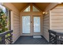 Inviting front entryway with double doors, triangular transom window, and a dark wooden deck with decorative railings at 1621 Ne 2Nd St # 601, Ocala, FL 34470