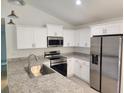 Well-equipped kitchen with white cabinets, stainless steel appliances, and granite countertops at 209 Sw Winding Hills Rd, Dunnellon, FL 34431