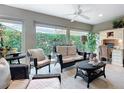 Cozy sunroom filled with natural light, wicker furniture, and serene views of the landscaped yard at 383 Harlow Ln, The Villages, FL 32163