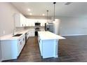 Modern kitchen boasts white cabinets, stainless appliances, and large center island with stone countertops at 4501 Sw 110Th Ln, Ocala, FL 34476