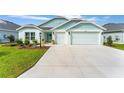Beautiful exterior of a light blue house with a well-maintained lawn and a spacious driveway at 503 Verlander St, The Villages, FL 34762