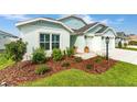 Landscaped front yard featuring lush green grass and meticulously arranged mulch beds with shrubs at 503 Verlander St, The Villages, FL 34762