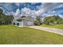 A one-story home featuring a two-car garage, concrete driveway, and lush green lawn at 5902 Sw 112Th Place Rd, Ocala, FL 34476