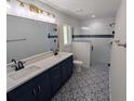 Updated bathroom with double sinks, decorative tile floor, and glass-enclosed shower at 6276 Nw 65 Nw Pl, Ocala, FL 34482