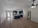 Open-concept living room featuring wood-look floors leading to a kitchen with an island and stainless appliances at 6276 Nw 65 Nw Pl, Ocala, FL 34482
