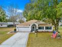 Inviting single-story home with a well-maintained lawn, two-car garage, and decorative driveway at 6450 Sw 83Rd Ln, Ocala, FL 34476