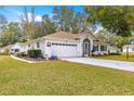 Classic single-story home with a manicured lawn, two-car garage, and nicely landscaped front yard at 6450 Sw 83Rd Ln, Ocala, FL 34476
