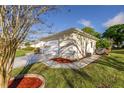 Side view showing the garage and landscaped walkway, plus mature tree at 9025 Se 136Th Loop, Summerfield, FL 34491