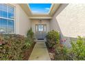 Inviting front entrance with a beautifully decorated door and lush landscaping with vivid colors at 10055 Sw 90Th Loop, Ocala, FL 34481