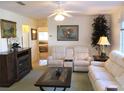 Cozy living room with ceiling fan, fireplace, and neutral color palette at 11552 Sw 138Th Ln, Dunnellon, FL 34432