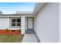 Close up of the front entrance with a gray framed window, colorful mulch, and gray painted porch at 13292 Sw 112Th Pl, Dunnellon, FL 34432