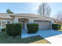 Close up of a single story home with a two car garage, manicured bushes, and covered entryway at 13677 Sw 40Th Avenue Rd, Ocala, FL 34473