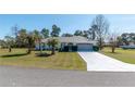 Single-story home featuring lush green lawn and mature landscaping with easy driveway access to a two car garage at 13677 Sw 40Th Avenue Rd, Ocala, FL 34473