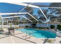 Beautiful screened-in pool with patio, a white picket fence, and some greenery at 13677 Sw 40Th Avenue Rd, Ocala, FL 34473