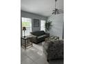 Bright living room featuring neutral tones, tile flooring, and a ceiling fan at 17799 Se 125Th Cir, Summerfield, FL 34491