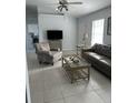 Bright living room featuring tile flooring, a sofa, and a ceiling fan at 17799 Se 125Th Cir, Summerfield, FL 34491