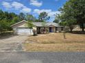 Single-Gathering home with a two-car garage and a well-maintained, though dry, front yard at 22 Hemlock Ter, Ocala, FL 34472