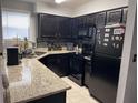 Kitchen features black appliances, tile backsplash and countertop at 2923 Antique Oaks Cir # 39, Winter Park, FL 32792