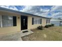 Home exterior featuring a black front door and a manicured lawn at 4 Pine Pass Ter, Ocala, FL 34472