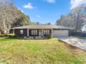 Well-maintained single-story home featuring a black brick facade, green grass, and manicured landscaping at 5906 Sw 108Th St, Ocala, FL 34476