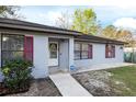 Charming single-story home featuring a well-maintained front yard, red window shutters and a covered entryway at 644 Sw 2Nd St, Ocala, FL 34471