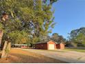 Single-story home with a long driveway, garage, large tree, and covered area perfect for gatherings at 6611 Sw 80Th Ave, Ocala, FL 34481