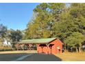 A large, red pavilion with a green roof is a great place to gather for fun activities at 6611 Sw 80Th Ave, Ocala, FL 34481