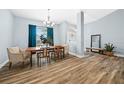 Open-concept dining room with wood-look floors and bright blue walls and window coverings at 6875 Se 11Th Pl, Ocala, FL 34472