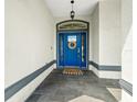 Beautiful blue front door with modern hardware, wreath, welcome mat, and stone tile entryway at 6875 Se 11Th Pl, Ocala, FL 34472
