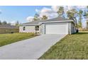 Charming single-story home featuring a well-manicured lawn and concrete driveway leading to the garage at 7772 Sw 146Th Lane Rd, Ocala, FL 34473