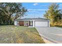 Well-maintained single-story home with a manicured lawn, a two-car garage, and an inviting entryway at 800 Marion Oaks Mnr, Ocala, FL 34473