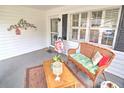 Inviting front porch with charming wicker bench and a small coffee table at 8888 Sw 95Th Ln # D, Ocala, FL 34481