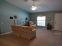 Inviting living room with neutral carpet, ceiling fan, and ample natural light from the arched window at 1546 Sw 153Rd Sw Ct, Ocala, FL 34481