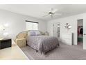 Bright main bedroom featuring neutral carpeting, a ceiling fan, and ample natural light from one window at 17421 Se 107Th Ct, Summerfield, FL 34491