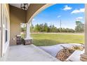 Inviting covered porch with stone accents and concrete flooring, perfect for enjoying the outdoors at 20396 Sw 79Th Lane, Dunnellon, FL 34431