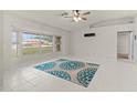 Bright living room featuring tile floors, large windows, and modern ceiling fan at 21 Pecan Pass Ter, Ocala, FL 34472