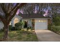 Charming single-story home at dusk, featuring a well-manicured lawn, mature tree, and an attached one car garage at 2418 Se 17Th Cir, Ocala, FL 34471