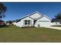 Beautiful single-story home featuring a manicured lawn and a two-car garage at 243 Marion Oaks Trl, Ocala, FL 34473