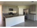 Modern kitchen with stainless steel appliances, gray cabinets and a granite-topped island at 243 Marion Oaks Trl, Ocala, FL 34473