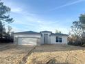 Beautiful single-story home featuring a white facade, a two-car garage, and modern architectural details at 2728 Sw 154Th Pl, Ocala, FL 34473