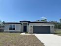 Charming single-story home with stone accents, gray garage door, and manicured front lawn at 2728 Sw 154Th Place Rd, Ocala, FL 34473