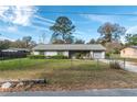 Welcoming single-story home featuring a gray exterior, fenced yard, and lush green lawn at 3204 Ne 16Th Ave, Ocala, FL 34479