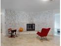 Bright living room featuring a stone wall fireplace, accent chair and tiled flooring at 3832 Se 2Nd St, Ocala, FL 34471