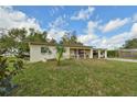 Charming one-story home with a porch swing, adjacent carport, and a spacious front lawn shaded by beautiful trees at 5812 Luzon Pl, Orlando, FL 32839