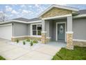 Inviting home entrance with stone pillar accents and a modern front door, creating curb appeal at 6 Dogwood Loop Ave, Ocala, FL 34472