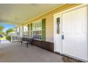 Inviting front porch featuring a white door and a comfortable bench, ideal for enjoying the outdoors at 7398 Hemlock Rd, Ocala, FL 34472