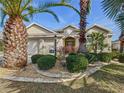 Lovely front exterior with mature landscaping, a three-car garage, and charming curb appeal at 805 Pickett Rd, The Villages, FL 32163