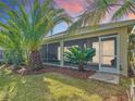 Enclosed screened patio with a view of the well-manicured backyard and tropical plants at 805 Pickett Rd, The Villages, FL 32163